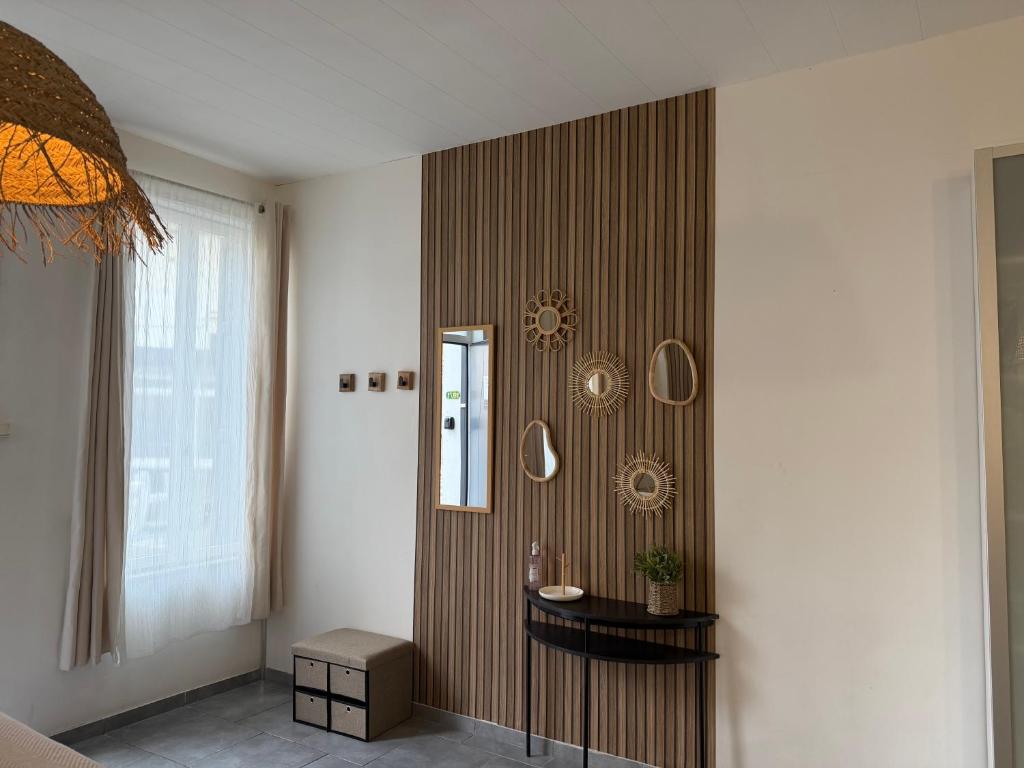 une pièce avec une table et des miroirs sur un mur dans l'établissement Le clair de lune, à Saint-Amand-les-Eaux