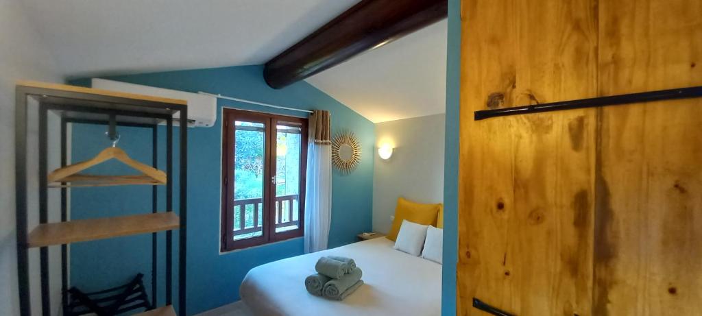 Un dormitorio con una cama blanca y una ventana. en Le Cabanon d'Andréa, en Forcalquier