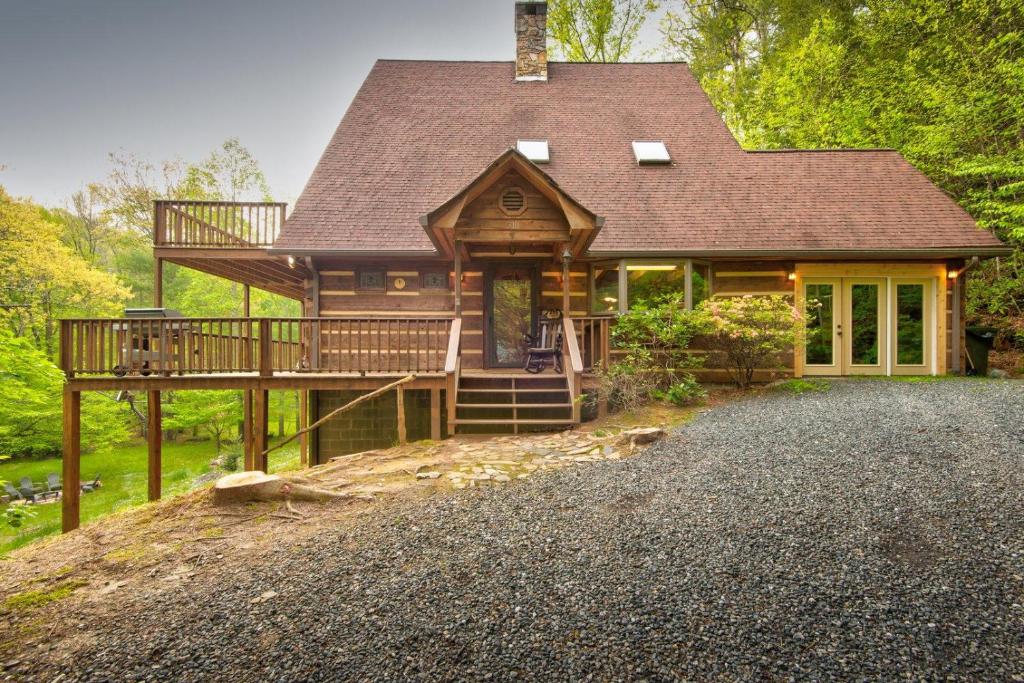 a large wooden house with a porch and a driveway at Hidden Creek Cabin in Fleetwood