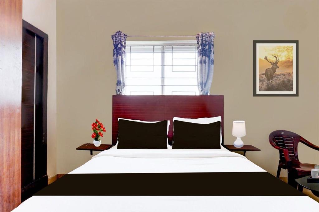 Un dormitorio con una cama grande y una ventana. en Hotel O Akshaya Enikepadu, en Vijayawāda