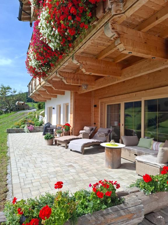 a patio with couches and flowers on a building at Sonnenappartements Madlstatthof in Wildschönau