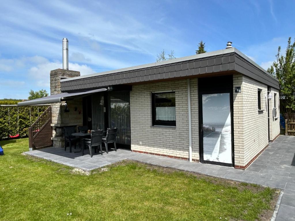 a small house with a patio and a table at Friesenkoje Tossens in Butjadingen