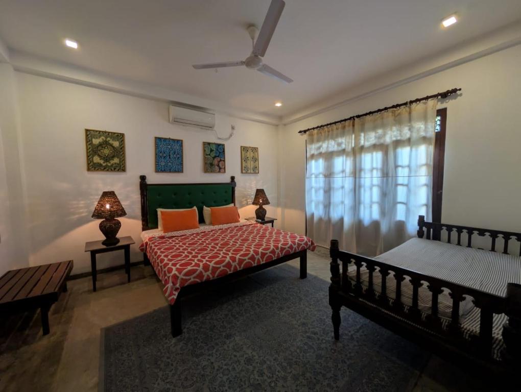 ein Schlafzimmer mit zwei Betten und einem Fenster in der Unterkunft Andy Home Stay, Balapitiya in Balapitiya