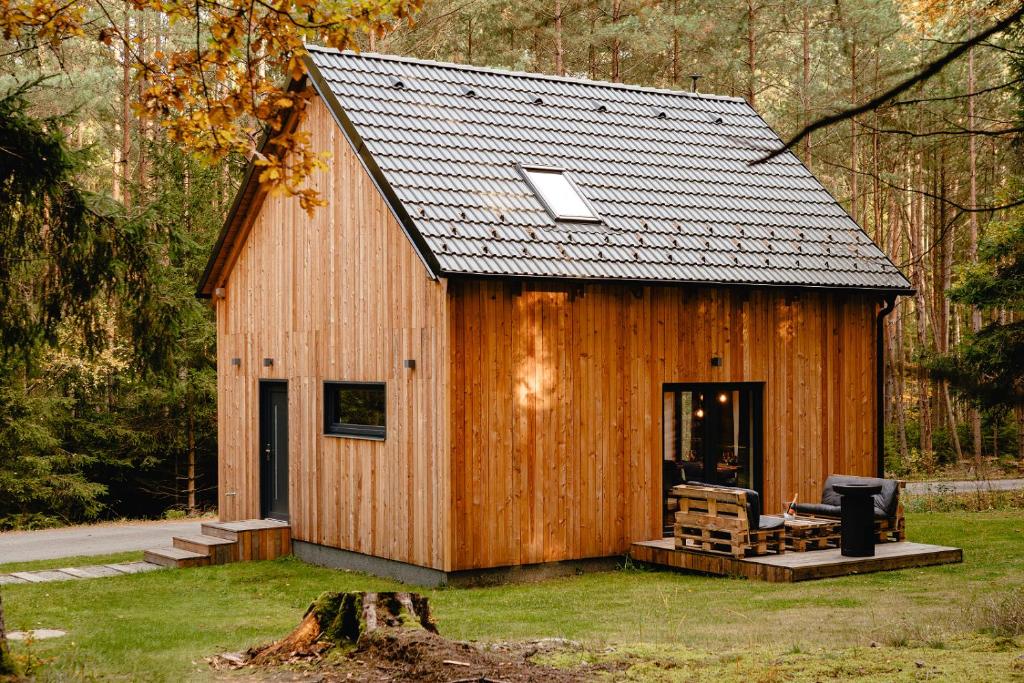 a large wooden cabin with a black roof at Modřínka 89 in Chlum u Třeboně