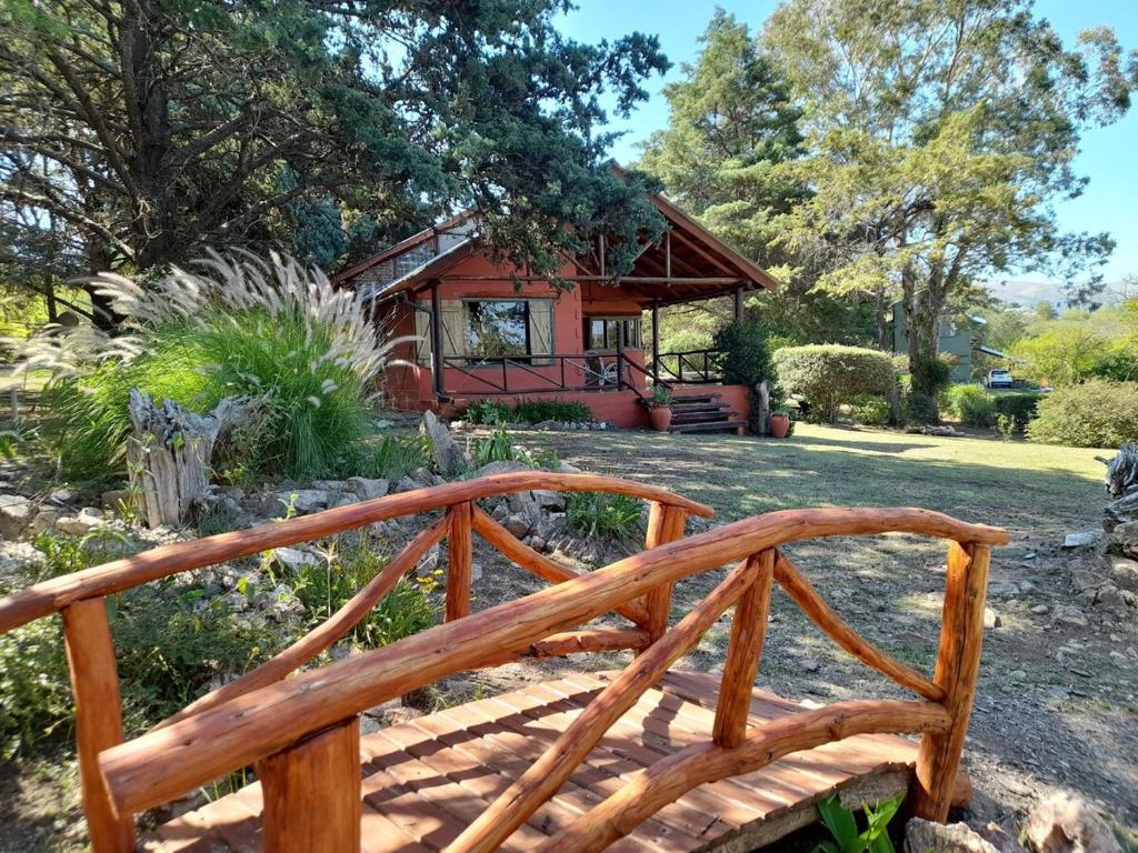 een houten bank voor een huis bij Suspiro de Montaña in Casa Grande