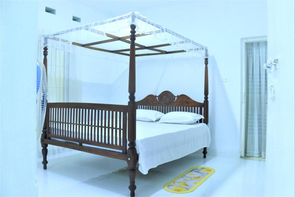 ein Schlafzimmer mit Himmelbett und gelbem Teppich in der Unterkunft Villa Heritance in Badulla