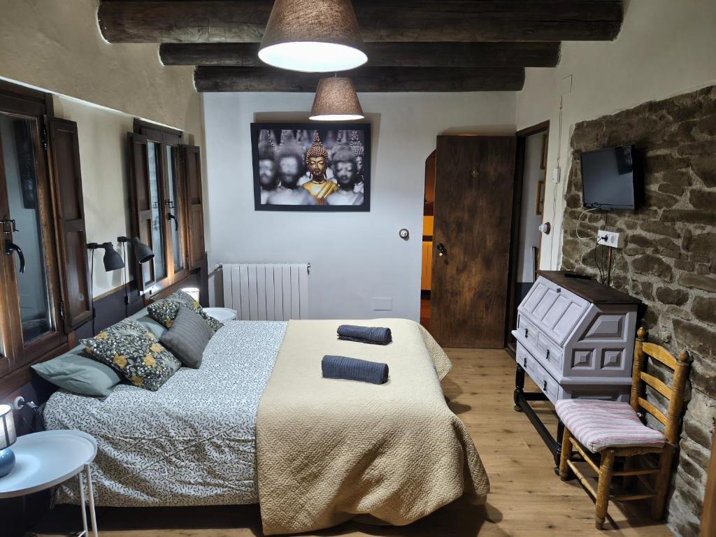 a bedroom with a bed and a table and a chair at A Boira Rural in Osia