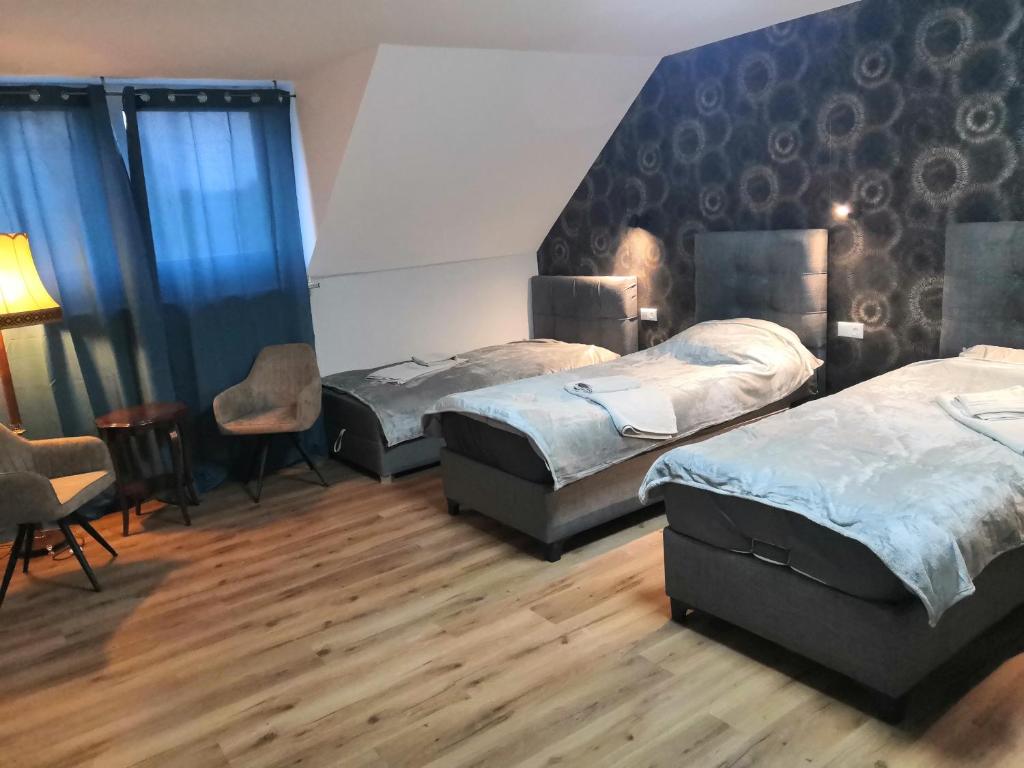 a room with three beds and a chair in it at Pension bei Laura in Schwerte