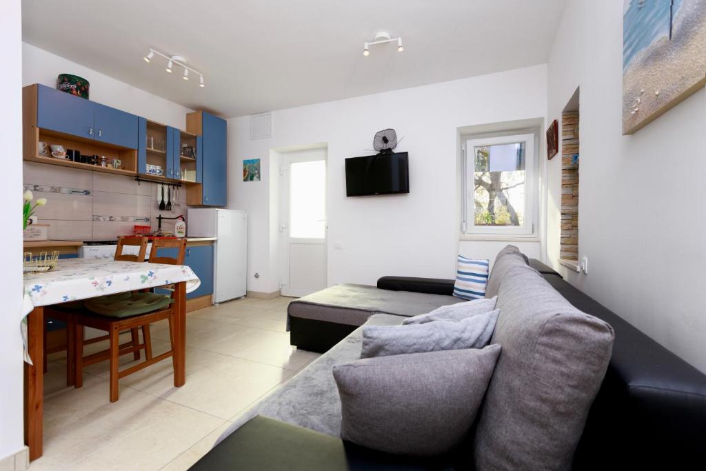 uma sala de estar com um sofá e uma mesa em Javor Residence Studio Apartman em Kostrena