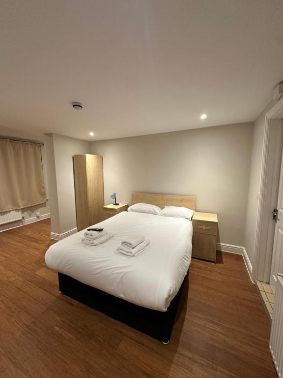a bedroom with a large bed with white sheets at Cavendish Annexe in High Wycombe
