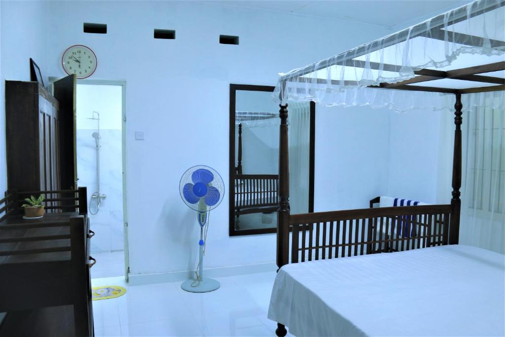 1 dormitorio con cama, espejo y ventilador en Villa Heritance, en Badulla