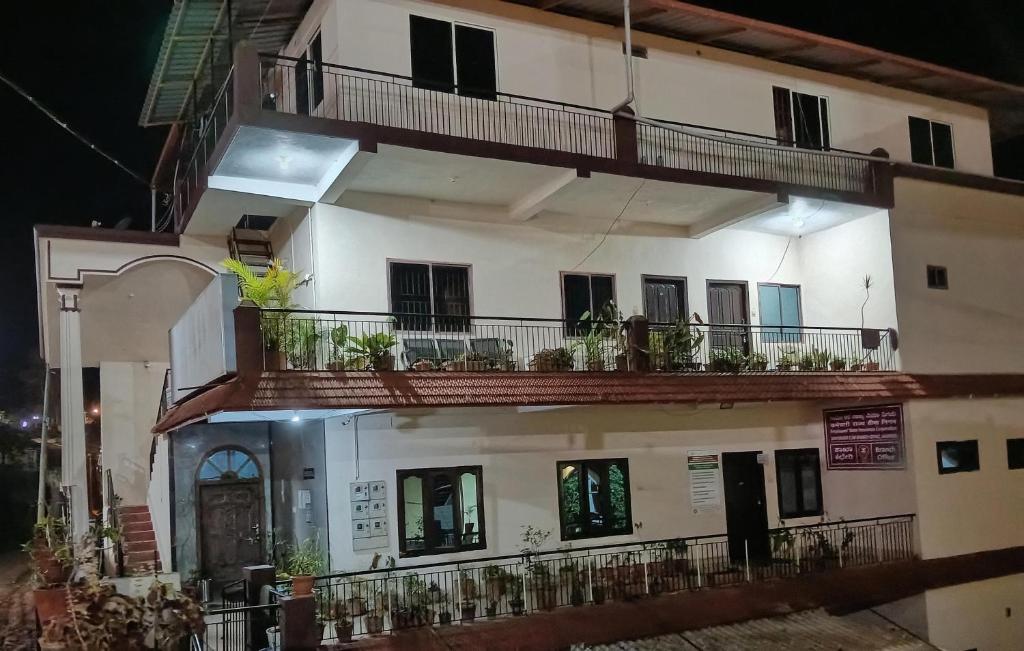 ein weißes Gebäude mit Balkonen und Pflanzen darauf in der Unterkunft Coorg homes & villas in Madikeri