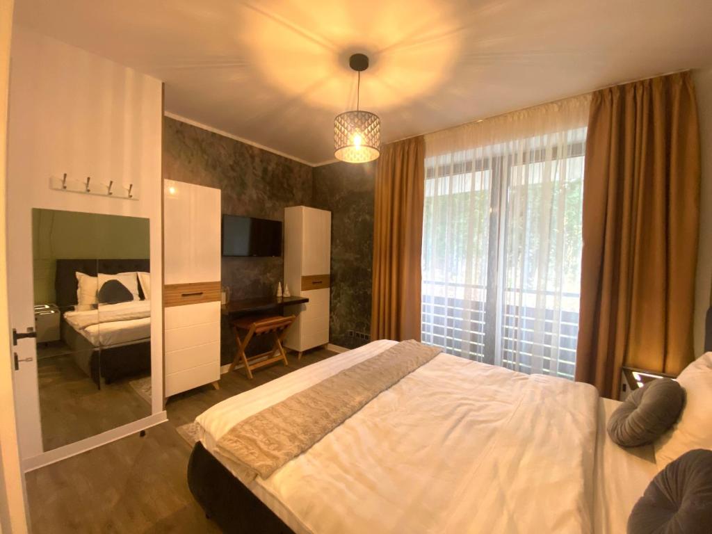 une chambre avec un lit, un bureau et une fenêtre dans l'établissement Fabulous Views Silver Mountain 3 Rooms Apartment, à Poiana Brasov
