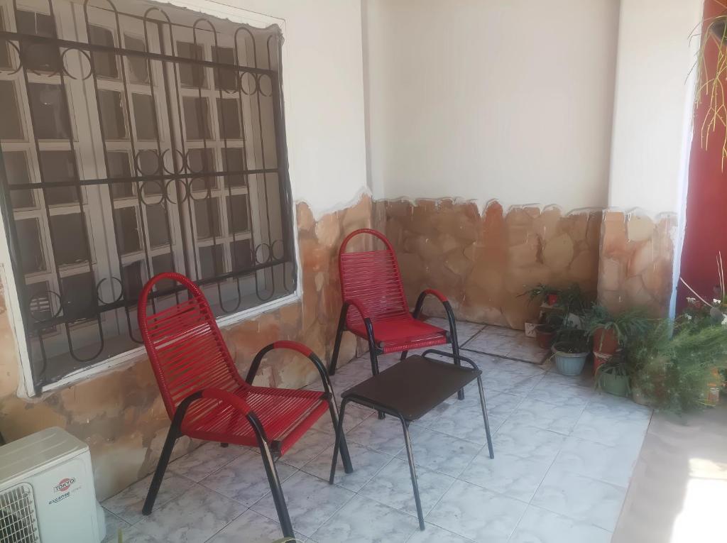 a pair of red chairs sitting on a porch at Miraflores 2- Calor de Hogar in Asuncion