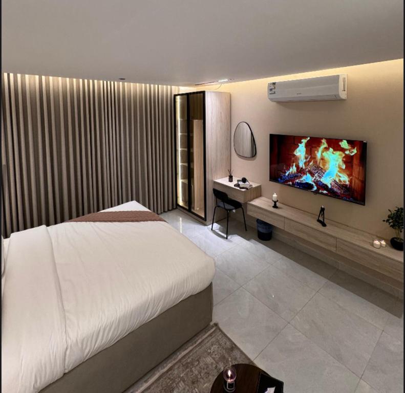 una camera da letto con un letto, una scrivania e una TV di استديو لوفينا 2 a Riyad