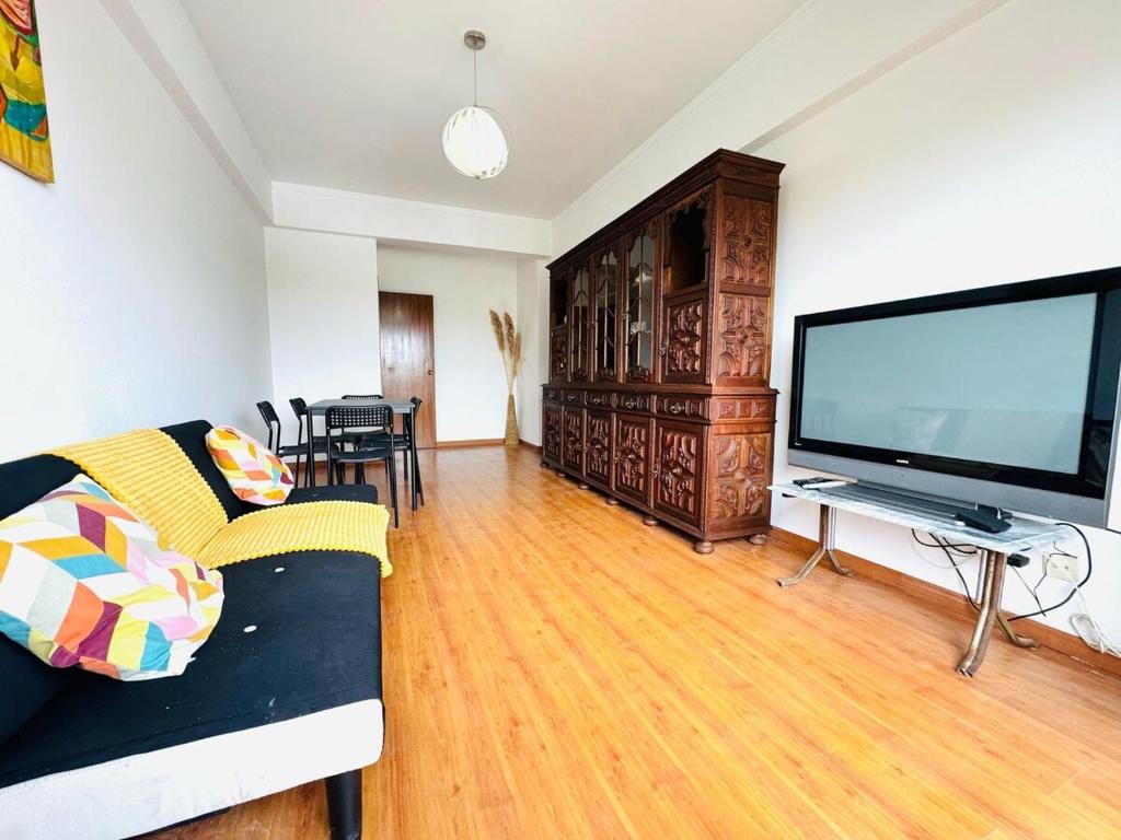 a living room with a large flat screen tv at Faro Family Apartment in Faro
