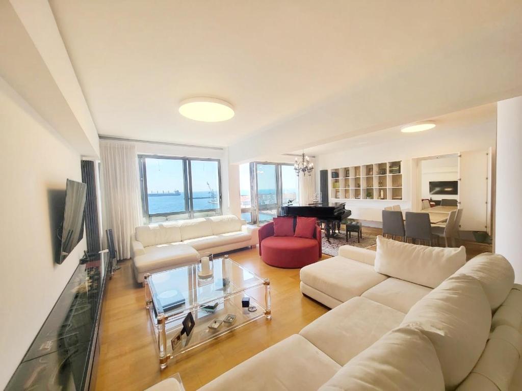 ein Wohnzimmer mit einer weißen Couch und einem Tisch in der Unterkunft Premium Seafront Suite in Thessaloniki