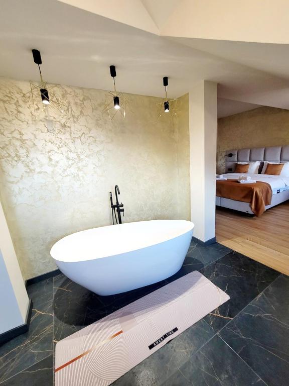 a white bath tub in a bathroom with a bedroom at Pensiunea Anton Pann in Sibiu
