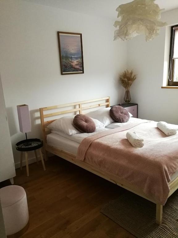 a bedroom with a large bed with two pillows at Apartament Graniczna in Bieniewice