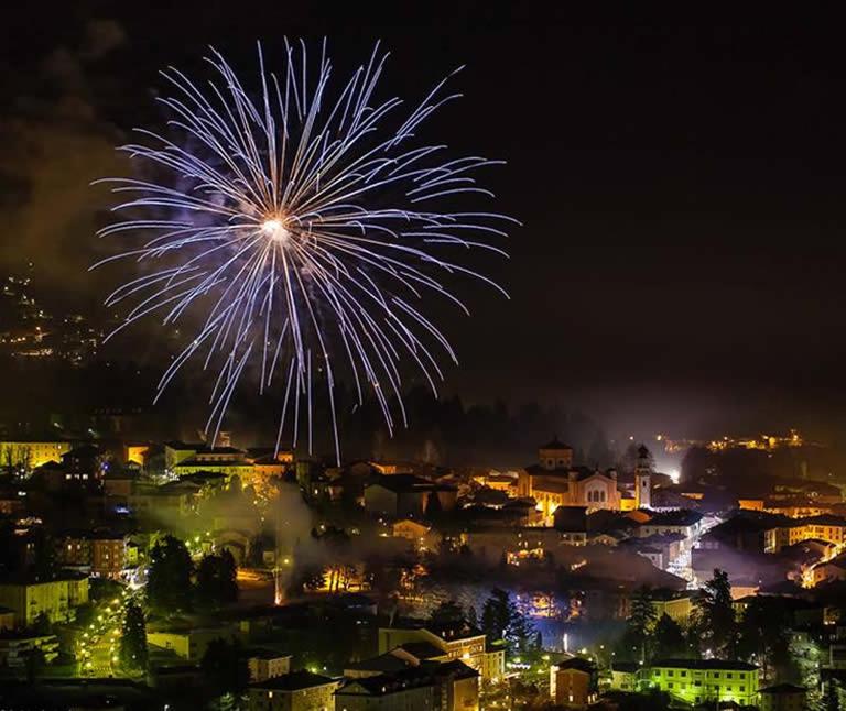 a fireworks display over a city at night at Nature Bio Hotel Elite in Levico Terme