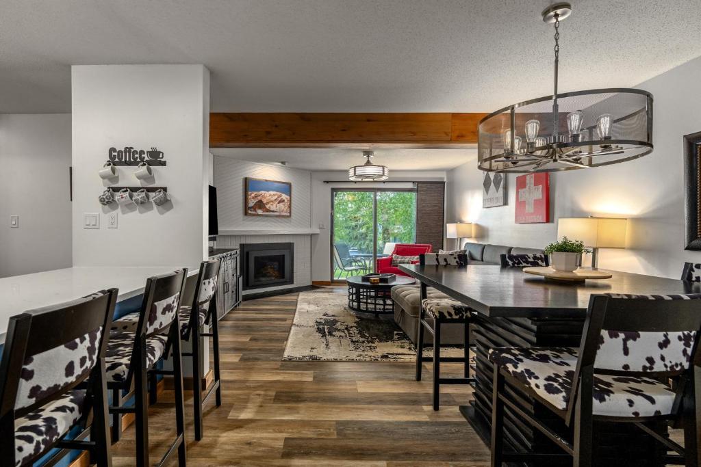 a dining room and living room with a table and chairs at Hot tubs and pool -Looping shuttle- Cozy fireplace in Steamboat Springs
