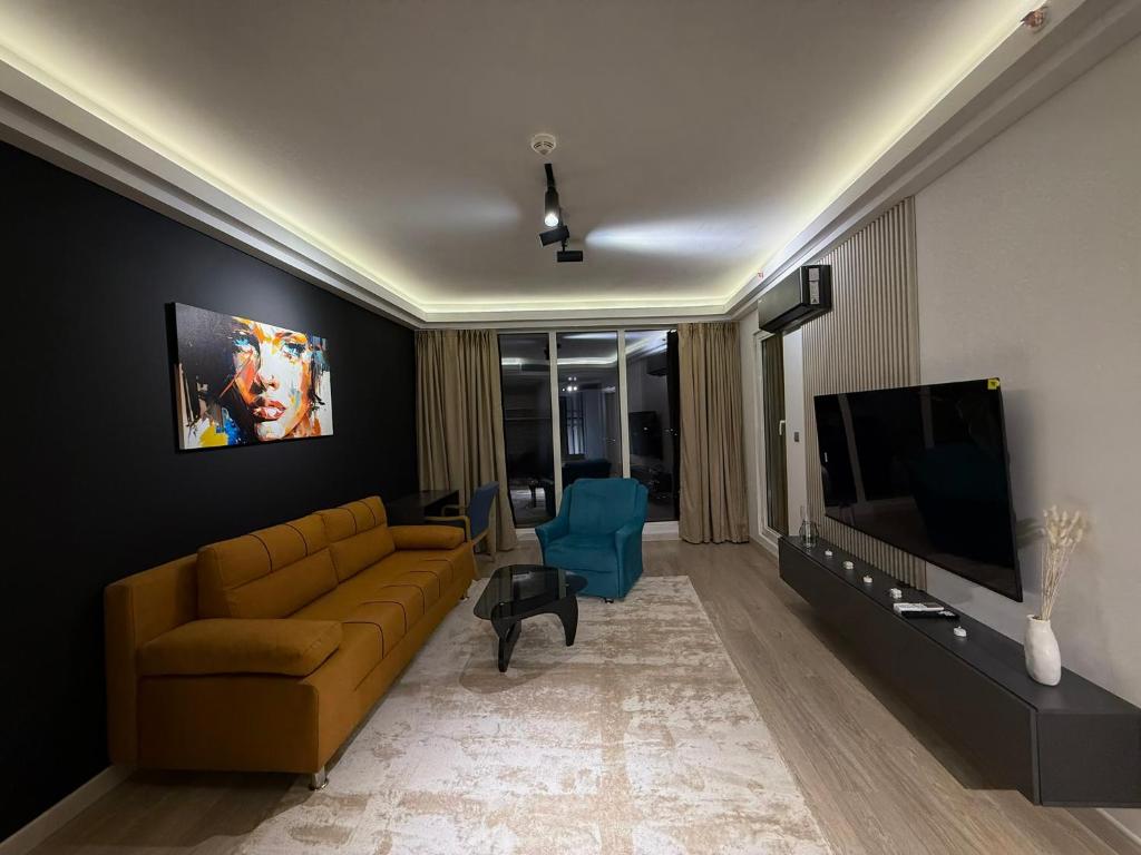 a living room with a couch and a flat screen tv at A2I - 33rd Floor SkyCity Residence With Skopje View in Skopje
