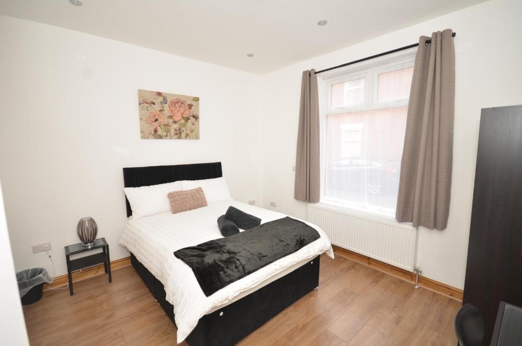 a bed in a room with a large window at JMG HOUSE - Quality Rooms in West Bromwich
