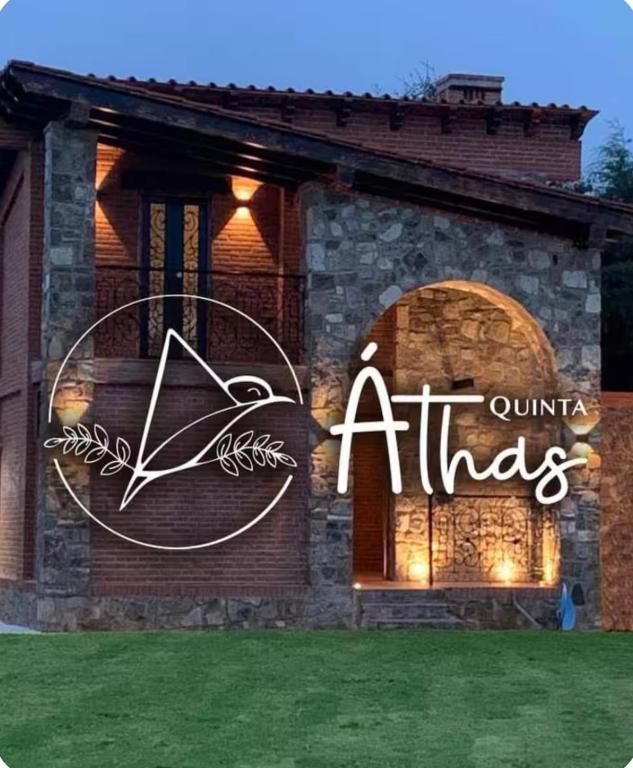 a sign on the side of a house with a window at Cabañas Quinta Áthas in Huasca de Ocampo