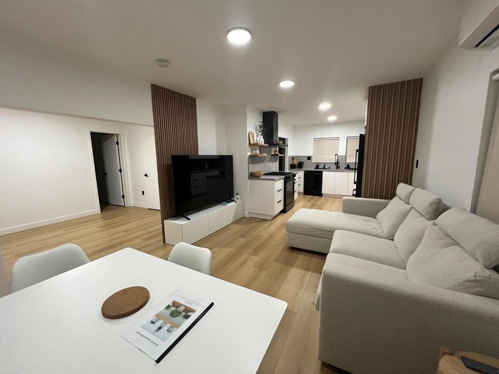 ein Wohnzimmer mit Sofa und Tisch in der Unterkunft East Hollywood Modern Spacious Bungalow in Los Angeles