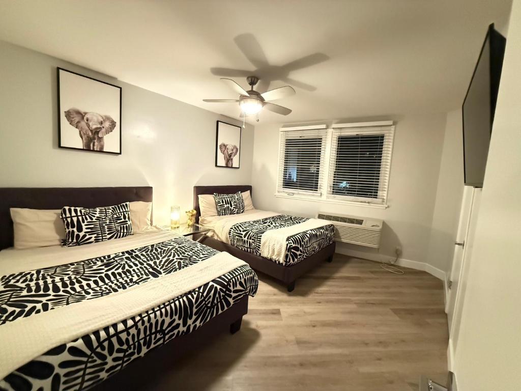 una camera da letto con due letti e un ventilatore a soffitto di Hollywood Apartment FREE Parking & Pool Close to Studios Universal a Los Angeles