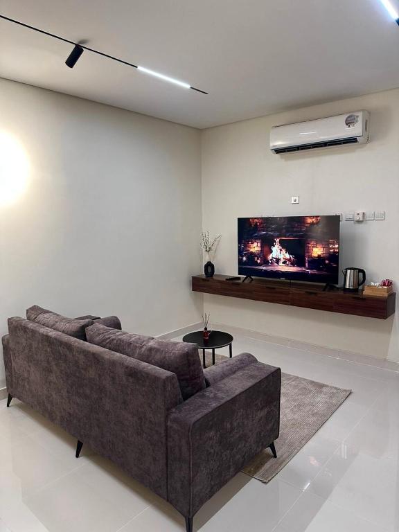un soggiorno con divano e TV a schermo piatto di Valley View a Nizwa