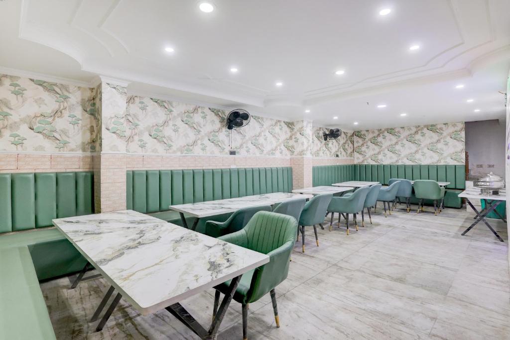 MohaliTownhouse Mohali Bus Terminal Formerly Hotel Hm Crystal的房间里一排桌椅，墙上贴着壁纸。