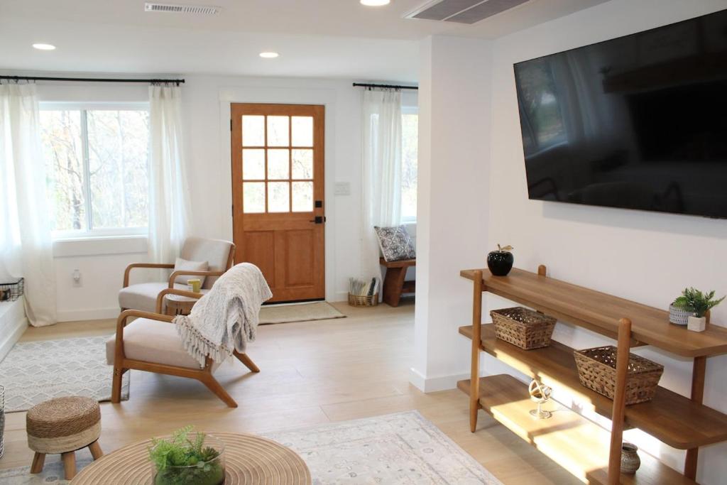 a living room with a large flat screen tv on a wall at Lake House get away in Whitsett