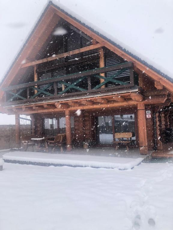 un edificio en la nieve con nieve cayendo sobre él en Zrub Kriváň Drevená chata s výhľadom na Tatry, en Závažná Poruba