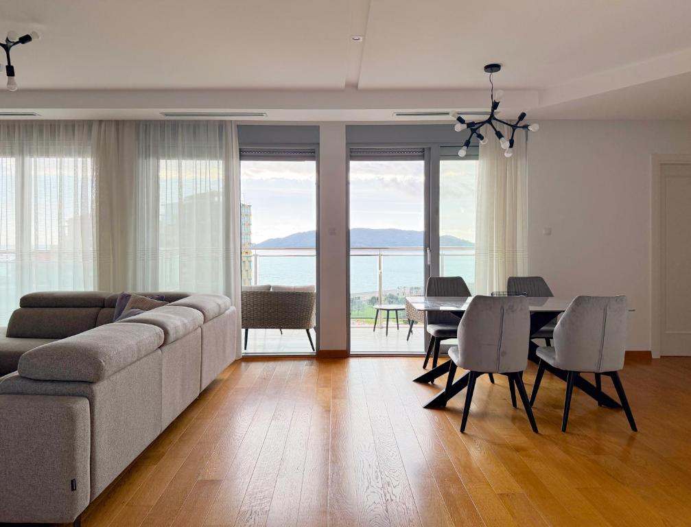a living room with a couch and a table and chairs at Seaview Apartment in Bečići
