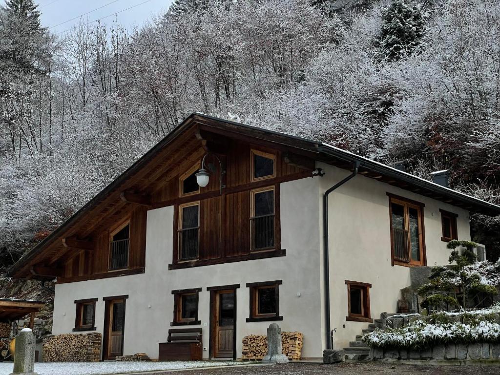 a house with snow on the roof of it at Sylva Smart Lodge in Spiazzo