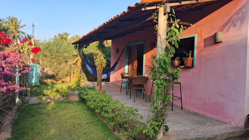 eine Veranda eines Hauses mit einem Tisch und Stühlen in der Unterkunft Casa Rosa in Praia de Moitas