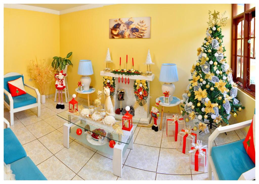 a living room with a christmas tree and christmas presents at Hospedaje La Casa Blanca in Urbanizacion Buenos Aires