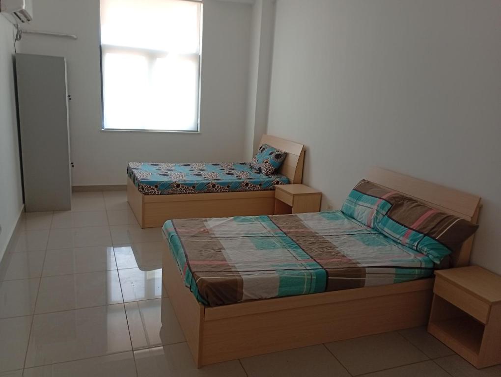 a bedroom with two beds and a window at Auberge de la lecture in Djibouti