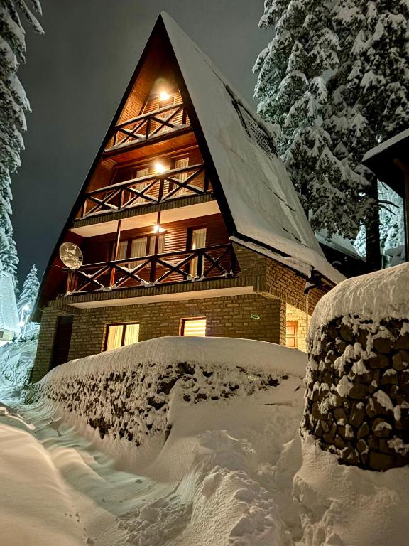a building covered in snow at night at KUĆA NENO in Vlasic