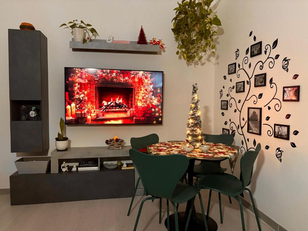 een woonkamer met een tafel en een tv bij Al Kicco D'oro - Intero appartamento in Lido di Ostia