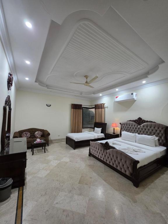 a large living room with two beds and a couch at Executive Galaxy Guest House Islamabad in Islamabad