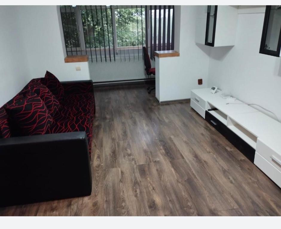 ein Wohnzimmer mit einem Sofa und Holzböden in der Unterkunft Apartament in Craiova