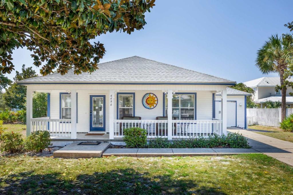 una pequeña casa blanca con una valla blanca en Emerald Escape-Crystal Beach-Private Pool-GolfCart, en Destin