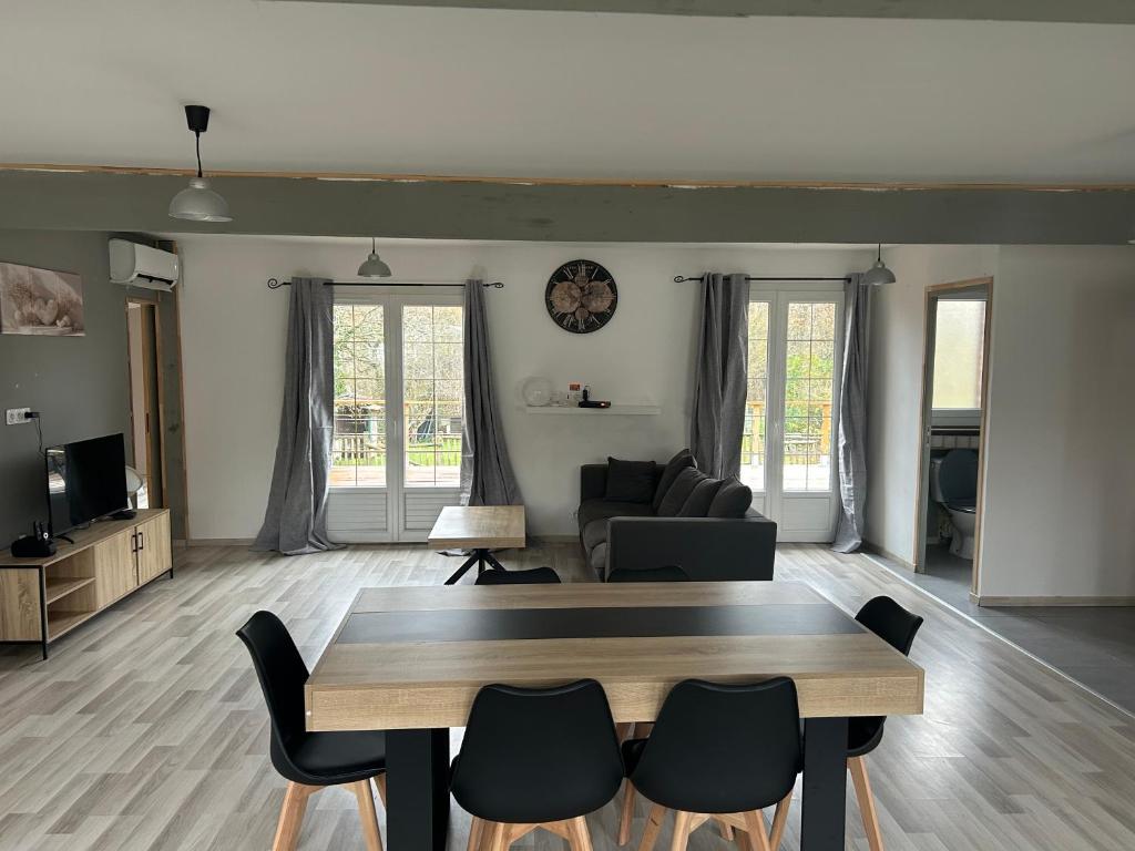 un salon avec une table et des chaises en bois dans l'établissement Maison de campagne très lumineuse au calme, à Diges