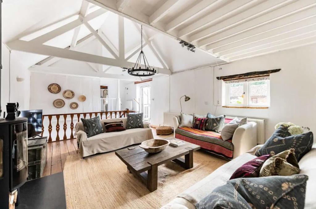 un salon avec un canapé et une table dans l'établissement Mulberry Coach House, à East Rudham