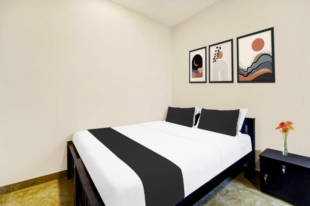 1 dormitorio con 1 cama en blanco y negro con cuadros en la pared en Super Collection O Saravanampatti, en Coimbatore