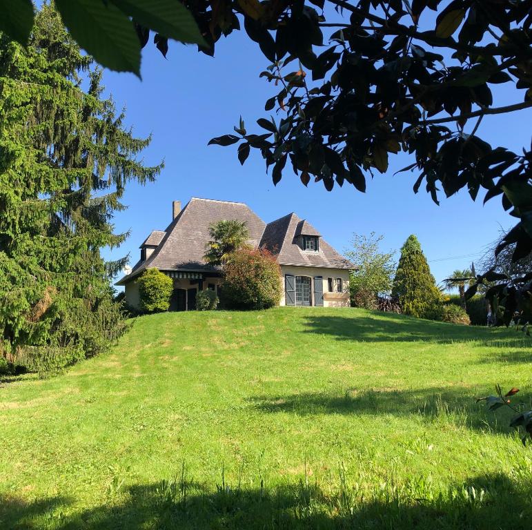 a house on a hill with a green lawn at Villa Gustavine - Maison d'Architecte in Ger