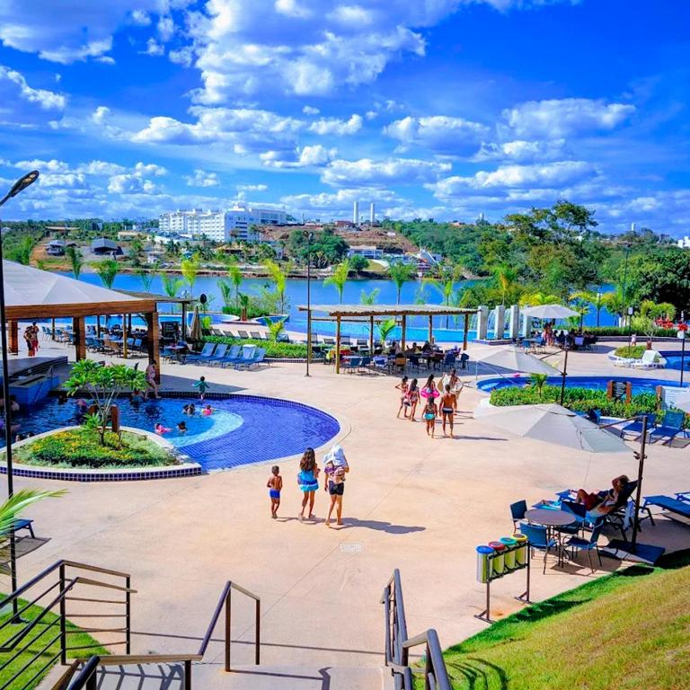 a group of people walking around a pool at a resort at Ilhas do Lago Eco Resort in Caldas Novas