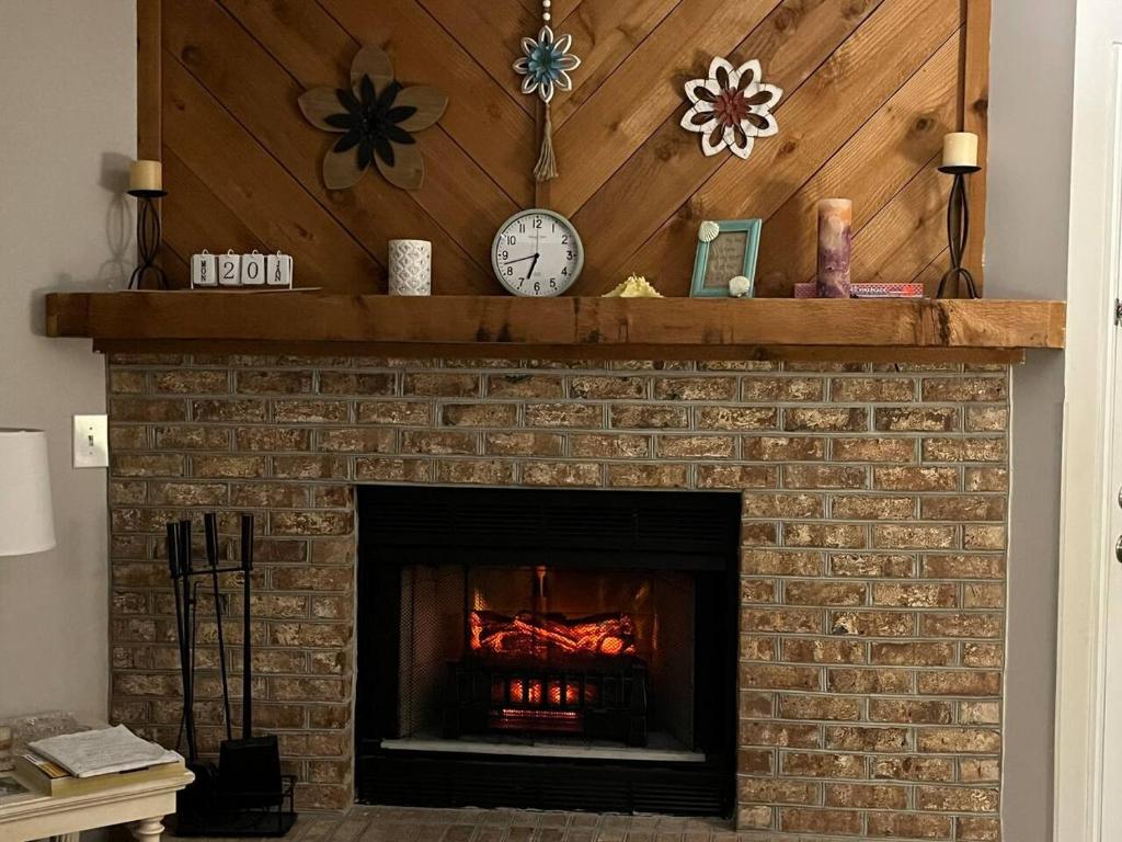 ein gemauerter Kamin mit einer Uhr darauf in der Unterkunft Cypress Bay Getaway in Little River
